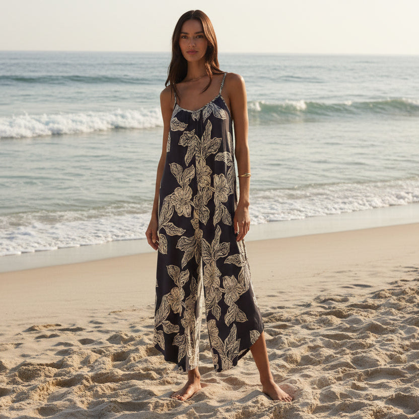 Z Supply Flared Asha Floral Jumpsuit on a model at the beach; navy gauze with white floral print, wide-leg.