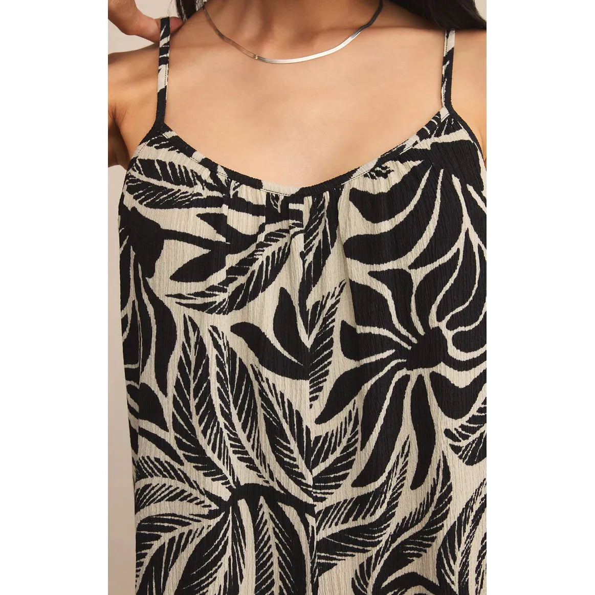 Z Supply Flared Palm Jumpsuit in textured gauze with black tropical palm print, spaghetti straps and relaxed silhouette