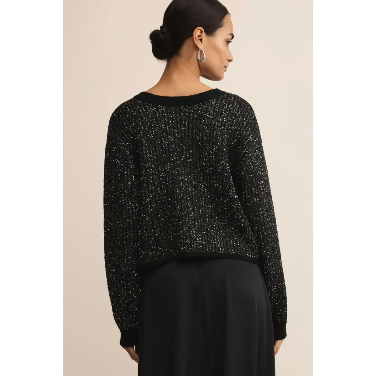 Back view of a woman wearing the Z Supply Gleam Sequin Sweater in black.