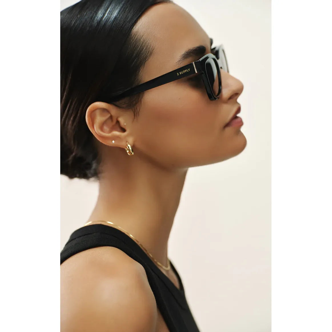 Side profile of a woman wearing Z Supply High Tide sunglasses with a small nylon-injected frame and polarized lenses.