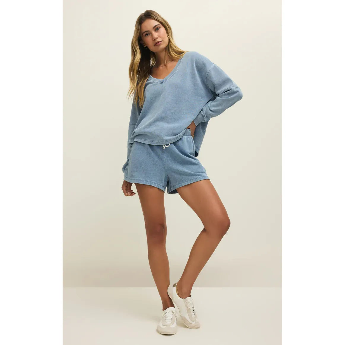Model wearing Z Supply Hunter Knit Denim Shorts with a matching oversized blue top and white sneakers.
