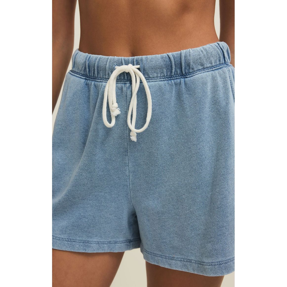 Model wearing light blue Z Supply Hunter Knit Denim Shorts with a high-rise fit, drawcord waist, and slash pockets.