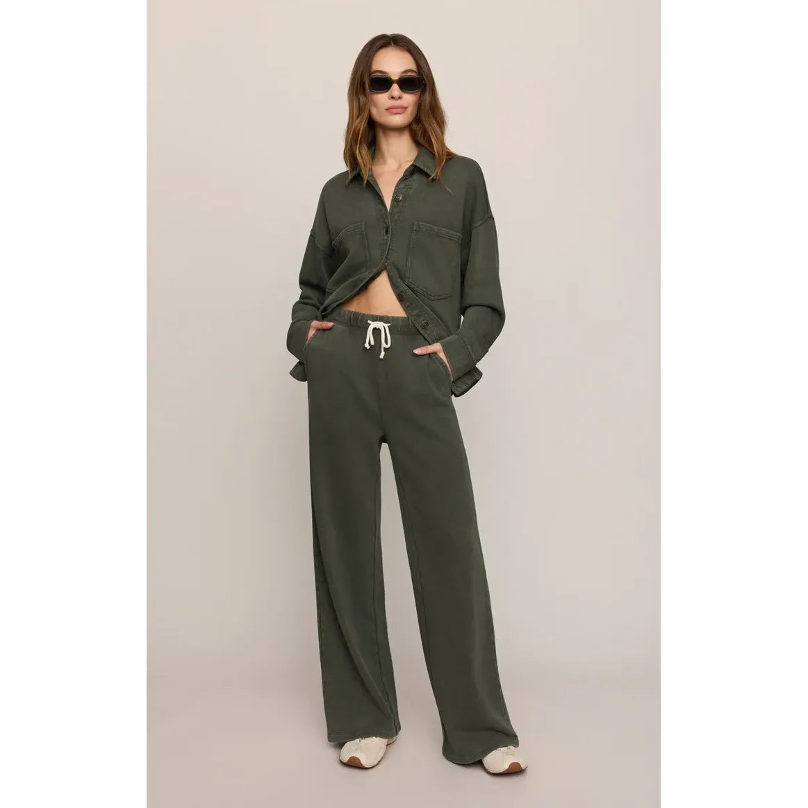 Olive green knit pants with white drawstring and slash pockets, crafted from soft cotton French terry for relaxed daily comfort.