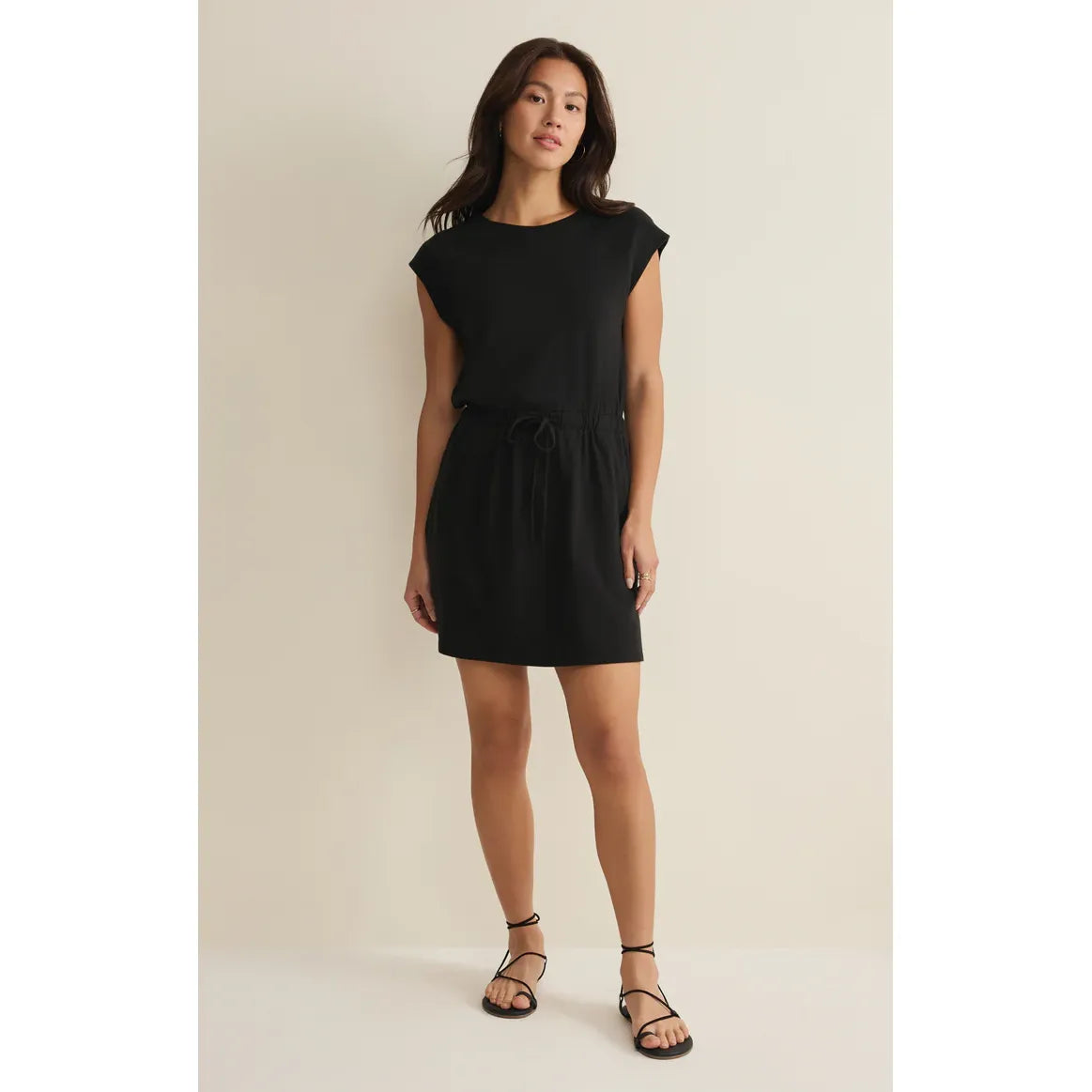 Model wearing black Z Supply Kalani Mini Dress with crewneck, elastic waistband, and sandals.