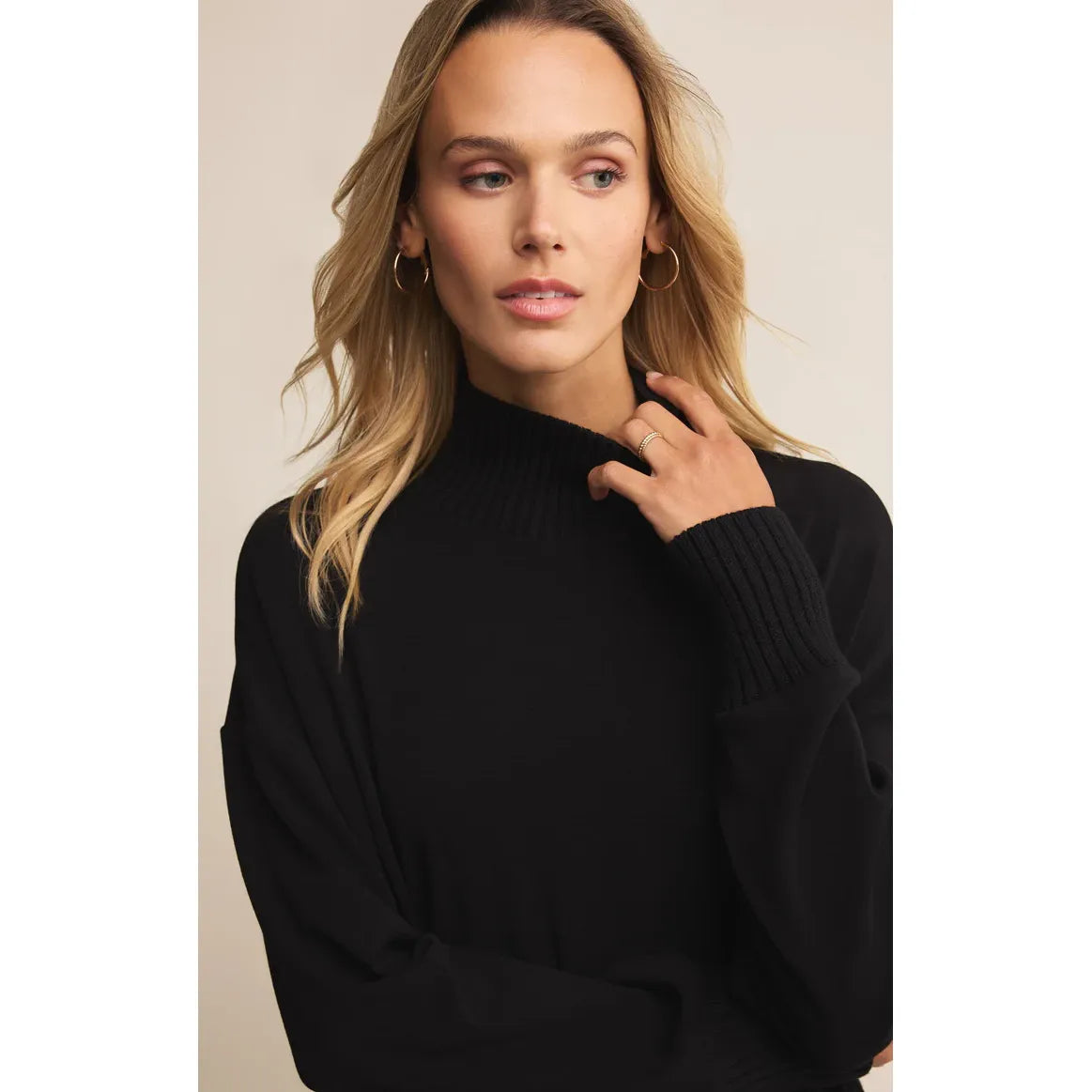 Model wearing Z Supply Sable Luxe Mock Neck Top in black midweight knit with ribbed cuffs.