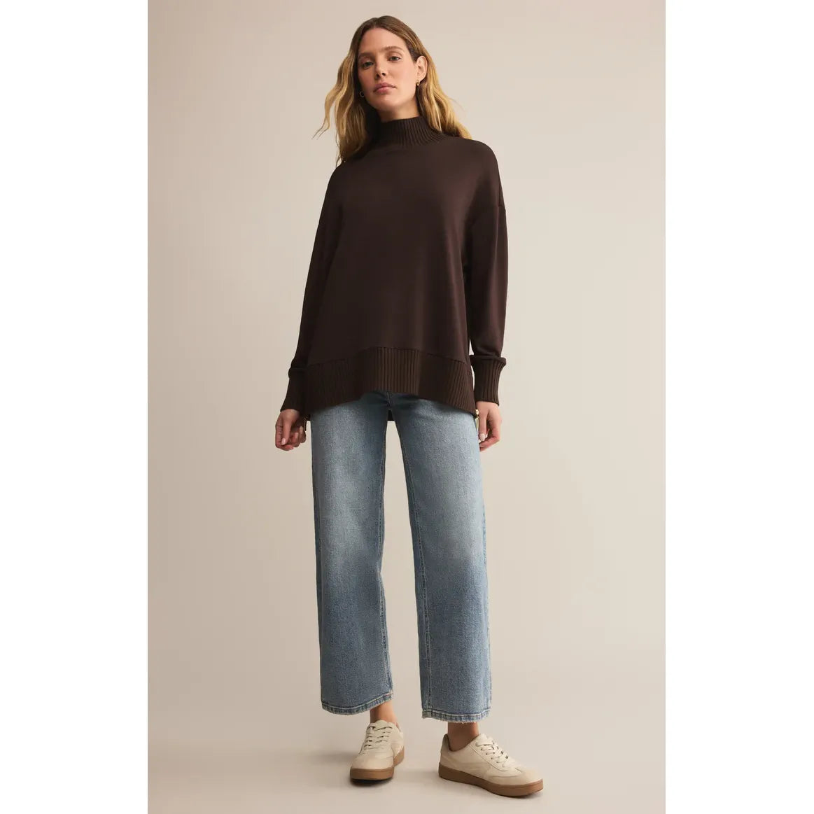 Z Supply Sable Luxe Mock Neck Top in dark brown, oversized knit with ribbed hem and cuffs, worn by a model with denim.
