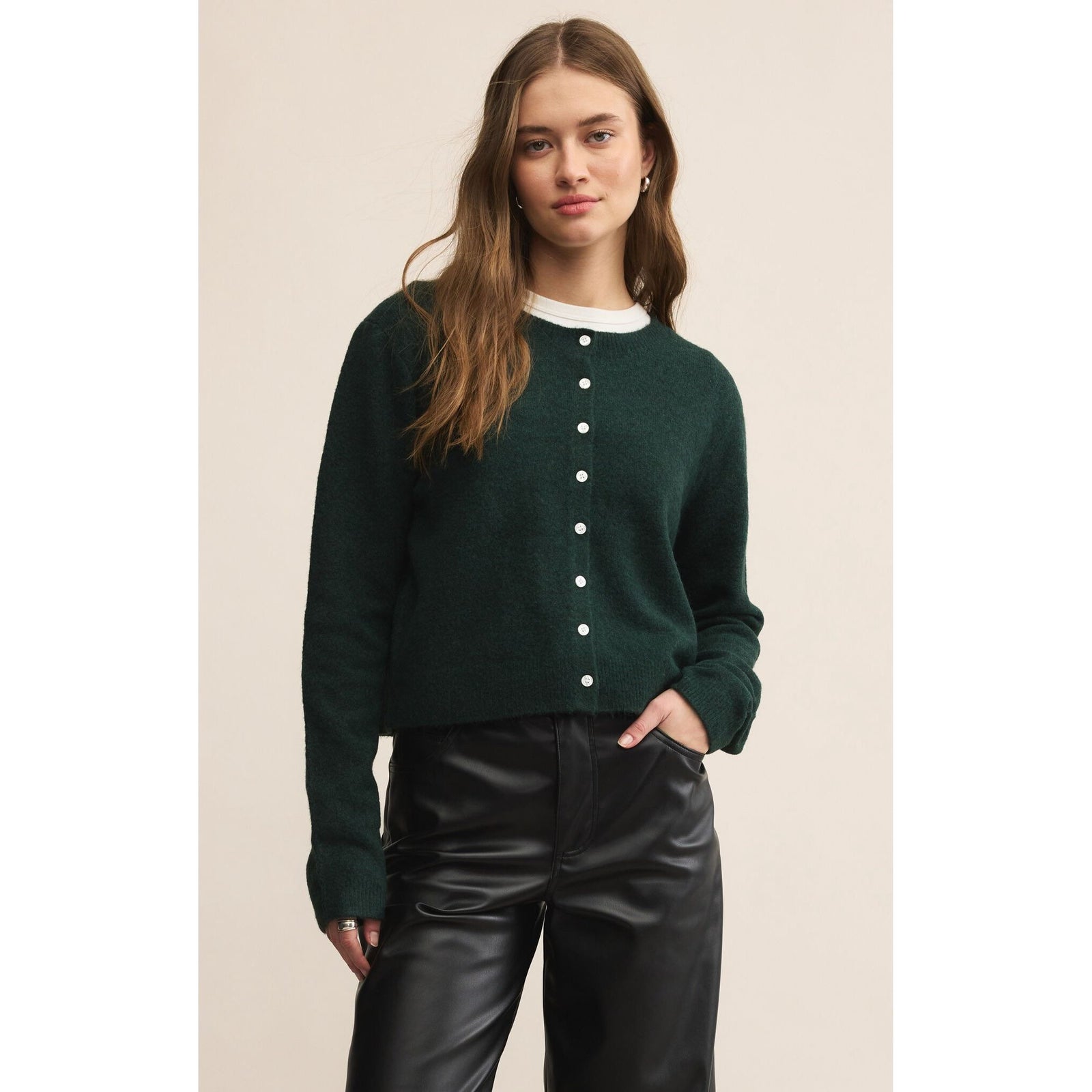 Model wearing Z Supply Medina Cardigan in deep green knit with crewneck and white buttons.