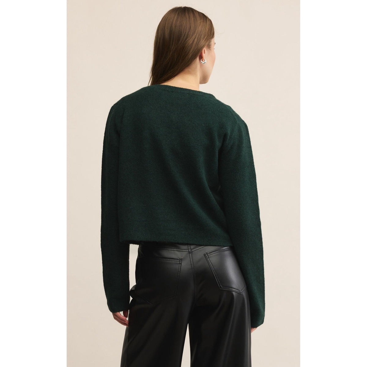 Z Supply Medina Cardigan in dark green, cropped crewneck knit, back view over black leather pants.