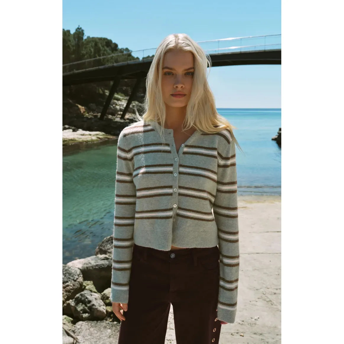 Retro sage green and brown striped cardigan with button-front closure, styled with blue jeans for cozy, nostalgic comfort.
