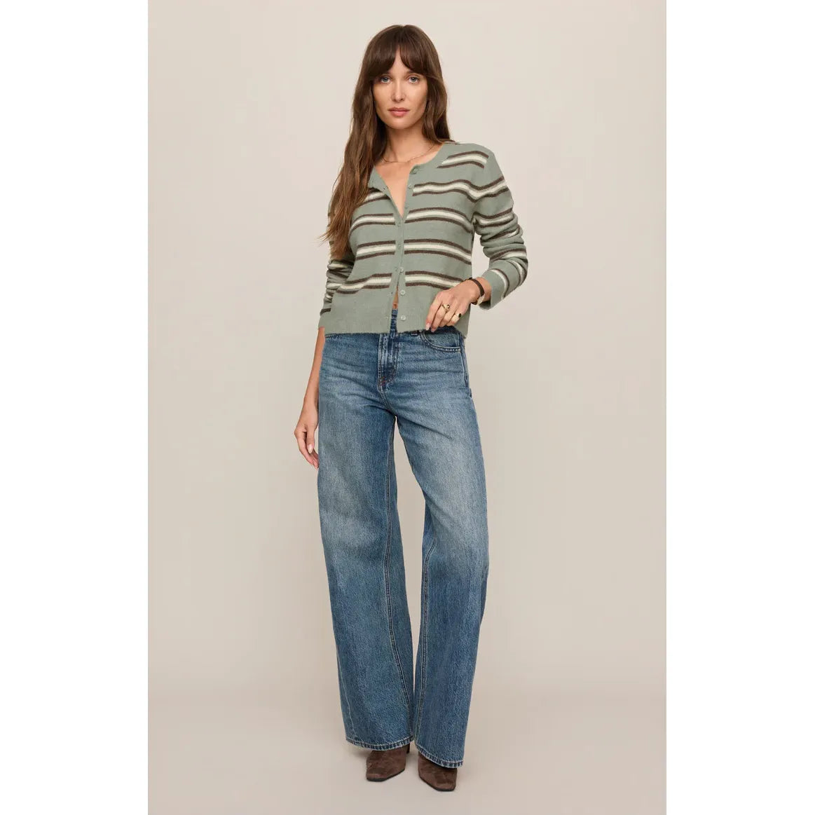 Retro-inspired sage green stripe cardigan with button-front closure paired with wide-leg denim jeans.
