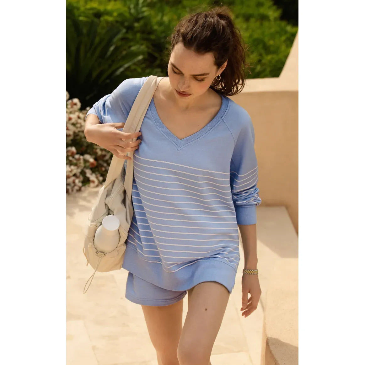 Z Supply Weekender V-Neck Stripe in light blue with white stripes, relaxed sweatshirt worn by a woman outdoors.