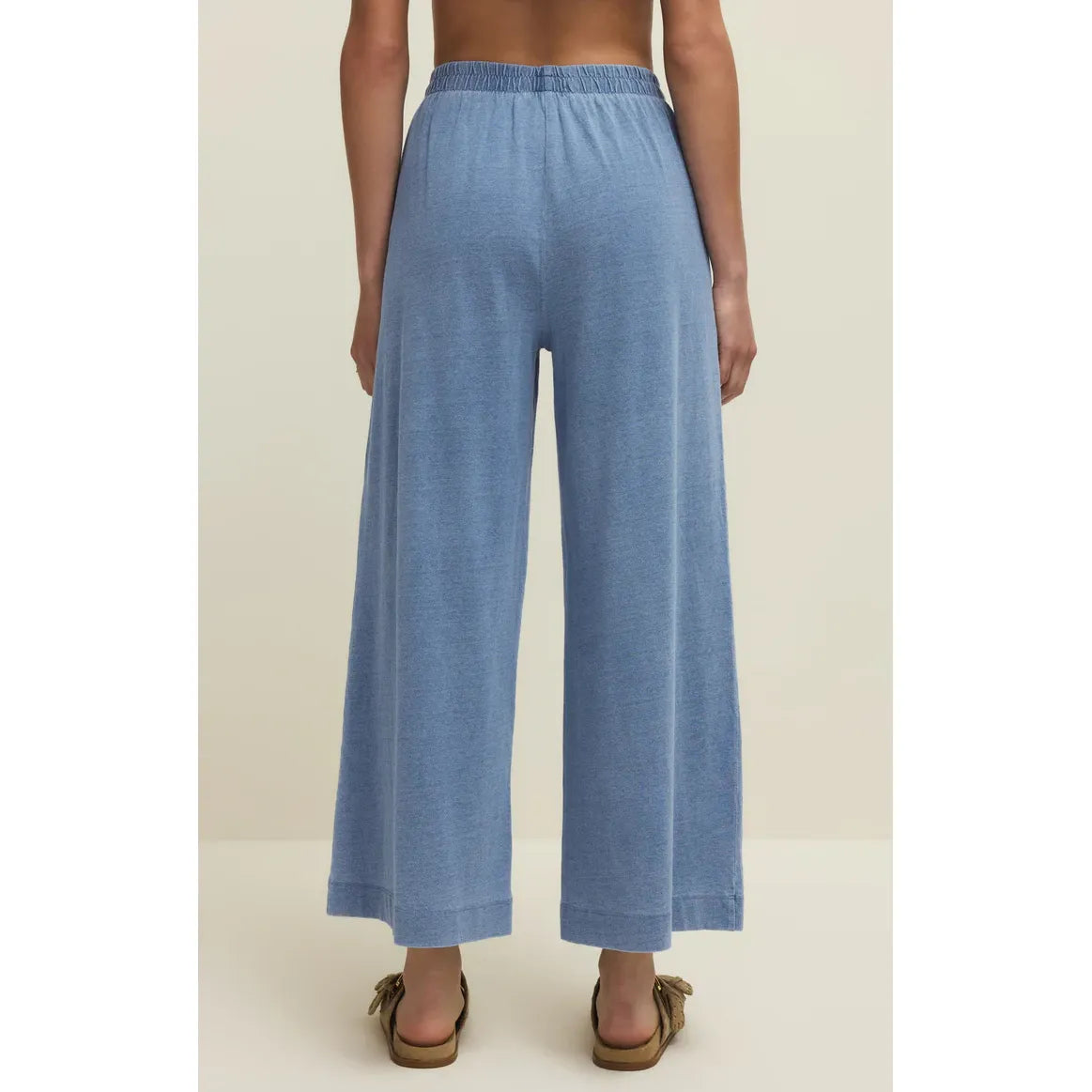 Back view of model wearing Z Supply Scout Jersey Denim Pant in light blue, wide-leg with elastic waist.
