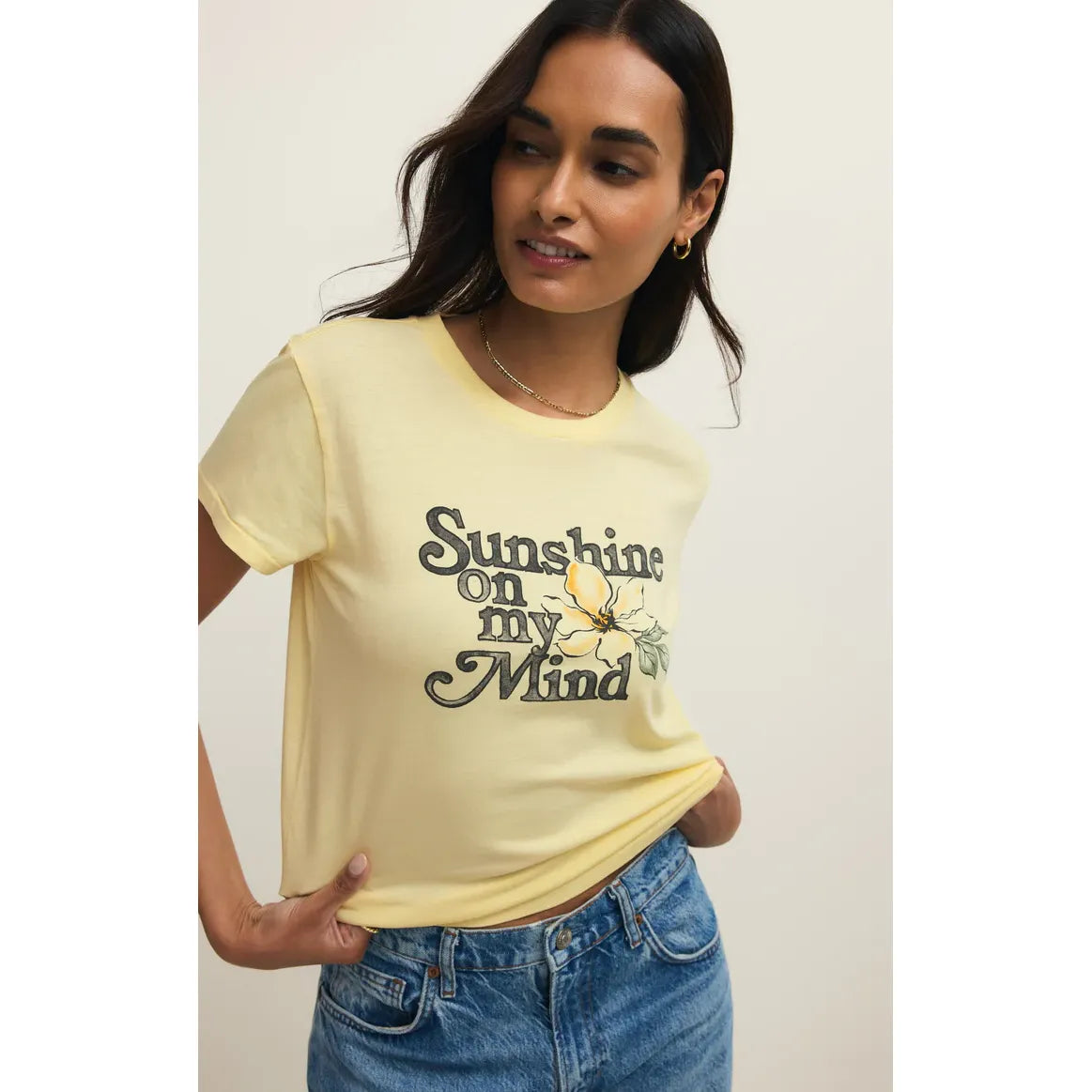 Z Supply Shine Tourist Tee in pale yellow with Sunshine On My Mind floral graphic, worn with denim.