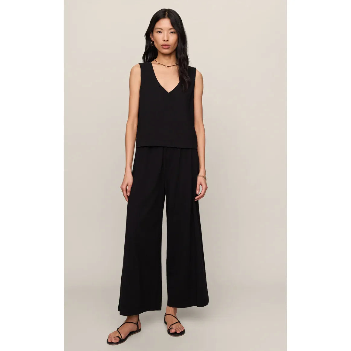 Model in black Z Supply Sloane V-Neck Tank with matching wide-leg pants, sleeveless V-neck, relaxed fit.