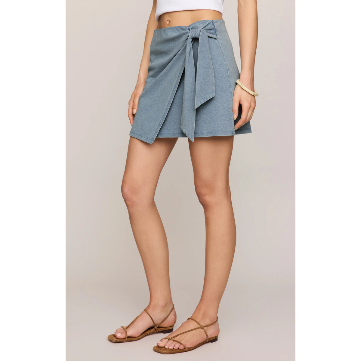 Z Supply Sora Denim Mini Skirt features sun-faded denim, wrap front, adjustable side tie, and hidden stretch waistband.