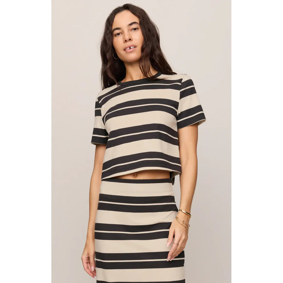 Model wearing a beige and black striped Z Supply Stellan Striped Tee with matching skirt.