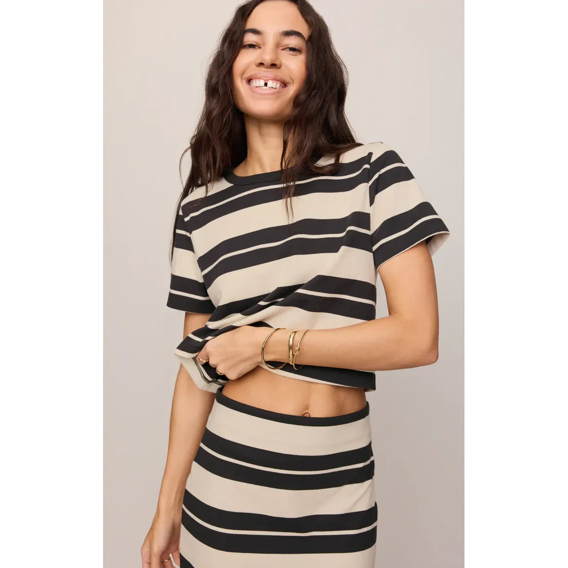 Model wearing Z Supply Stellan Striped Tee in beige and black stripes with a matching striped skirt.