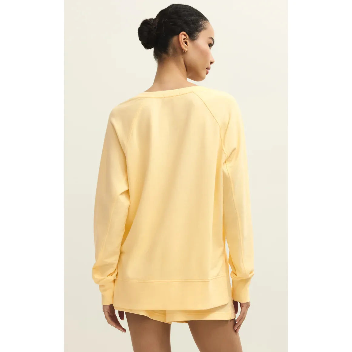 Back view of model wearing pale yellow Z Supply Weekender V-Neck sweatshirt.