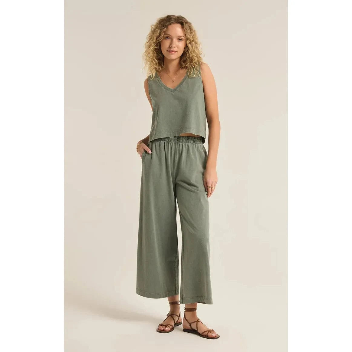 Stylish woman wearing Z Supply Sloane V-Neck Tank - Sale in olive green, paired with relaxed pants for effortless chic.