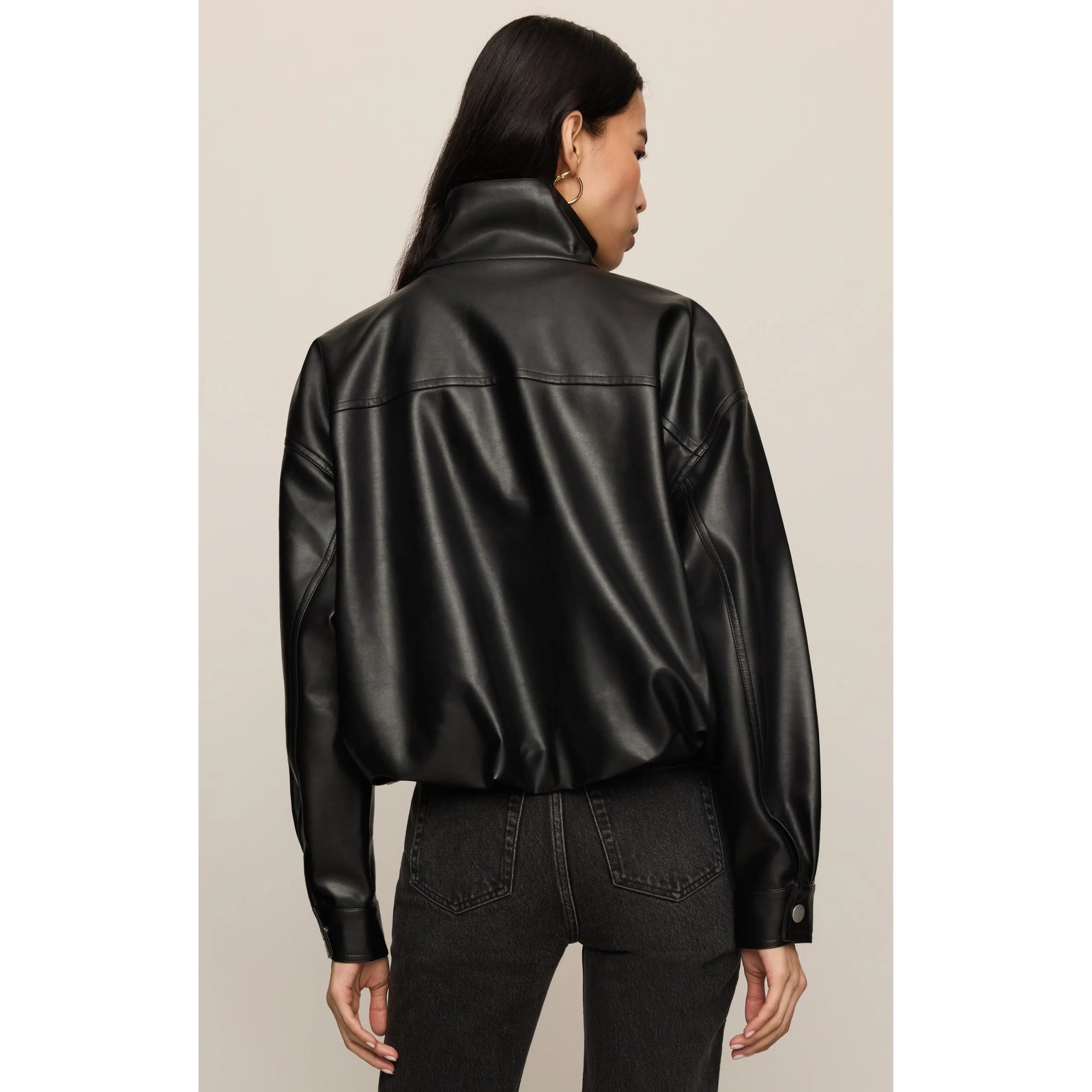 Back view of a black faux leather bubble jacket featuring a high funnel neck, sculpted shape, and voluminous hem gathered at the waist.