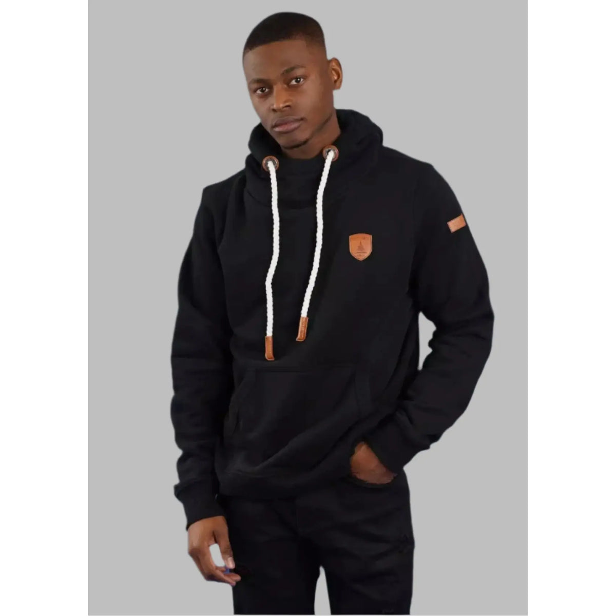 Wanakome Cascade Hoodie worn by Khaleel (size Large, 6 ft) in black with white drawstrings and leather patches.